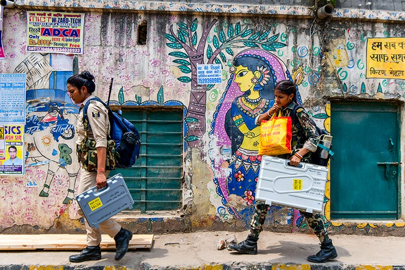 Security personnel carry Electronic Voting Machines (EVMs) and other voting materials as they leave for polling stations in Patna on May 31, 2024, on the eve of the seventh and final phase of voting in India"s general election.