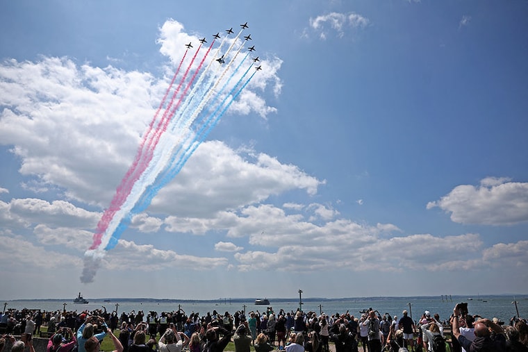 Members of the public watch as the British Royal Air Force"s (RAF) aerobatic team, the "Red Arrows", perform a flypast above HMS St Albans, a Type 23 Frigate, during a UK national commemorative event to mark the 80th-anniversary commemorations of Allied amphibious landing (D-Day Landings) in France in 1944, in Southsea Common, southern England, on June 5, 2024. Heads of state and veterans are due to mark the anniversary of D-Day on June 6, a date that was key to Allied Europe"s eventual victory against the Nazis in World War II.