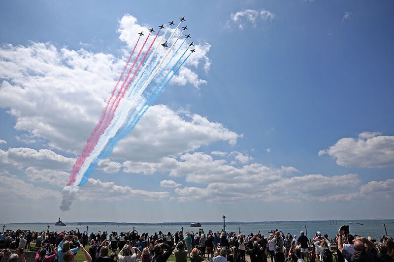 Members of the public watch as the British Royal Air Force"s (RAF) aerobatic team, the "Red Arrows", perform a flypast above HMS St Albans, a Type 23 Frigate, during a UK national commemorative event to mark the 80th-anniversary commemorations of Allied amphibious landing (D-Day Landings) in France in 1944, in Southsea Common, southern England, on June 5, 2024. Heads of state and veterans are due to mark the anniversary of D-Day on June 6, a date that was key to Allied Europe"s eventual victory against the Nazis in World War II.