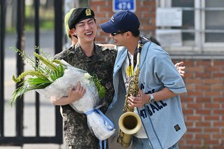 K-pop boy band BTS member Jin (L) is greeted by fellow BTS member RM (R) after being discharged from his mandatory military service outside a military base in Yeoncheon. Image: Photography Jung Yeon-je / AFP