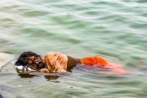 A man sleeps in the river Ganga on a hot summer day in Varanasi on June 18, 2024.