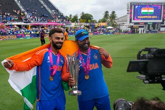 India"s Virat Kohli (left) and captain Rohit Sharma pose with the winners trophy after defeating South Africa in the ICC Men"s T20 World Cup final cricket match at Kensington Oval in Bridgetown, Barbados on Saturday, June 29, 2024.