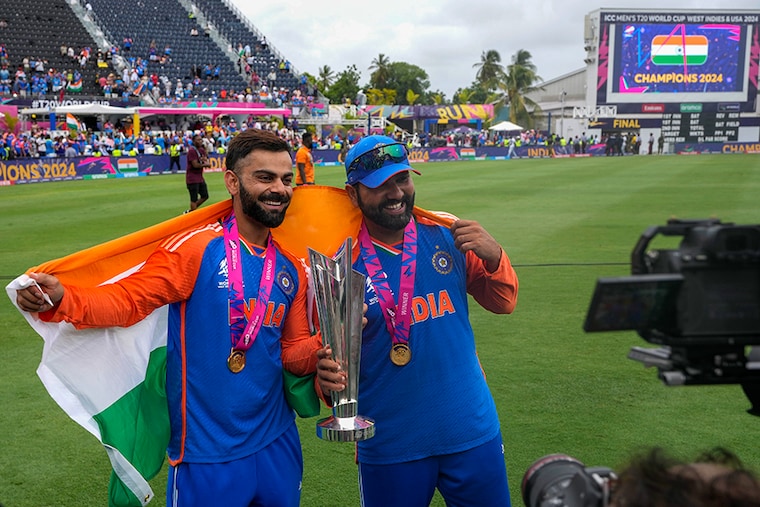 India"s Virat Kohli (left) and captain Rohit Sharma pose with the winners trophy after defeating South Africa in the ICC Men"s T20 World Cup final cricket match at Kensington Oval in Bridgetown, Barbados on Saturday, June 29, 2024.