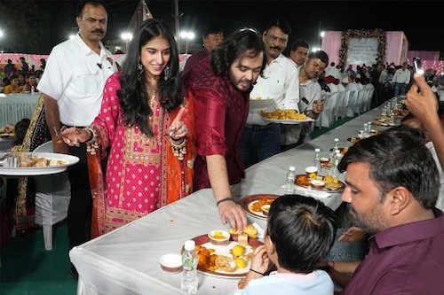Bride-to-be Radhika Merchant and groom-to-be Anant Ambani serve food during Anna Seva on Wednesday, February 28, 2024 at Jogwad, Jamnagar, Gujarat.