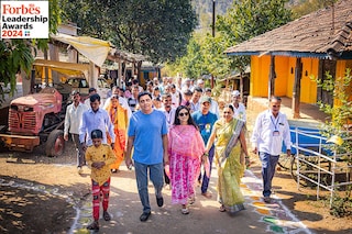 Ronnie (in T-shirt) and Zarina Screwvala (in pink kurta) visiting a village in Nashik where they work with the community
Image: Apoorva Salkade For Forbes India