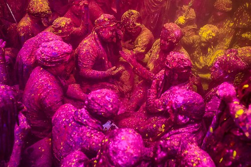 Devotees smear coloured powder and water as they celebrate Holi, at the Radharani temple in Barsana, Uttar Pradesh, on March 18, 2024. A vibrant festival of colors, Holi celebrates the arrival of spring.