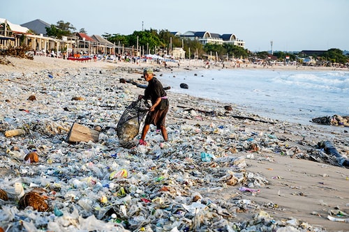 A man collects recyclable items to sell amid plastic and other debris washed ashore at Kedonganan Beach near Denpasar on Indonesia"s resort island of Bali on March 19, 2024. Image: SONNY TUMBELAKA / AFP© A man collects recyclable items to sell amid plastic and other debris washed ashore at Kedonganan Beach near Denpasar on Indonesia"s resort island of Bali on March 19, 2024. Image: SONNY TUMBELAKA / AFP©