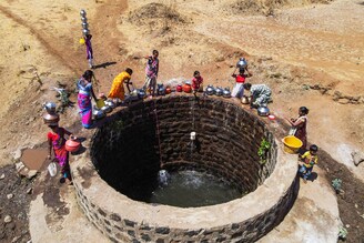 A drone view of women drawing water from a well on a hot day in Kasara, Maharashtra, India, May 1, 2024. Eastern India experienced its hottest April on record as a heatwave scorched parts of the country, killing at least nine people. The India Meteorological Department forecast above-normal temperatures for May, too.