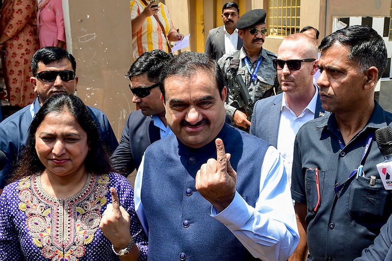 Gautam Adani, Chairperson of Indian conglomerate Adani Group and his wife Priti Adani show their inked finger after casting their ballot to vote in Ahmedabad on May 7, 2024, during the third phase of voting of India"s general election.