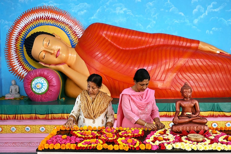 Devotees place flowers near a Buddha statue at a Buddhist temple in Chennai, India, on May 23, 2024, to celebrate Buddha Purnima, which marks Gautama Buddha"s birth anniversary.