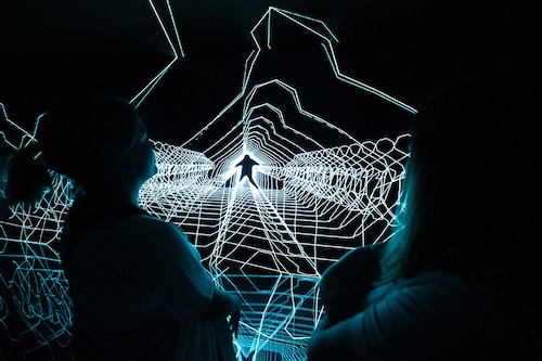 People enjoy "Music:Response" experimental audiovisual installation by The Chemical Brothers and Smith & Lyall during the opening of The Cube audiovisual space at Casa Batllo in Barcelona on May 24, 2024. Image: Josep Lago / AFP