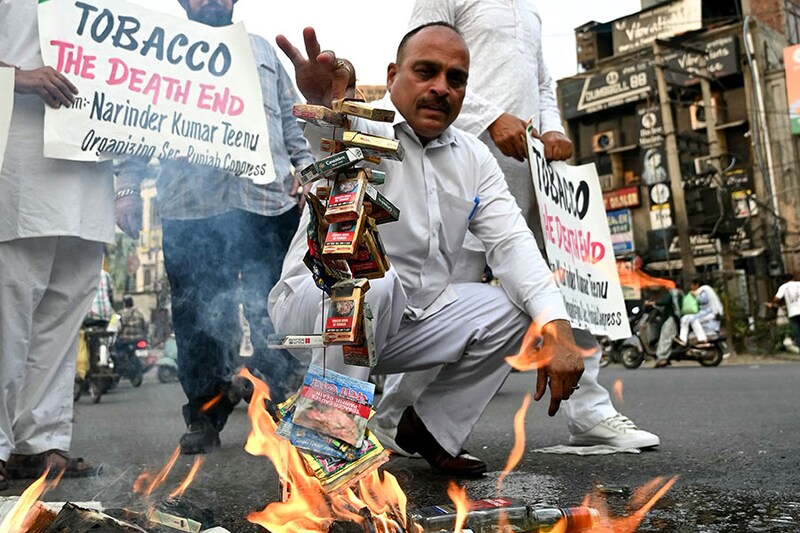 Congress party workers burn packets of cigarettes during a demonstration on the eve of "World No Tobacco Day" in Amritsar on May 30, 2024. Narinder Nanu / AFP