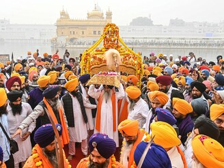 A Sikh priest (C) carries the Guru Granth Sahib during a religious procession at the Golden Temple in Amritsar on November 14, 2024, on the eve of Guru Nanak Dev"s birth anniversary.