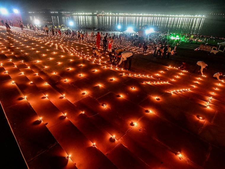 Devotees light traditional oil lamps as they celebrate the Hindu festival of "Dev Deepawali" at Sangam, the confluence of the rivers Ganges, Yamuna and mythical Saraswati in Prayagraj on November 15, 2024.