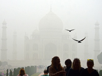 Tourists visit the Taj Mahal on a cold, smoggy morning in Agra on November 18, 2024. On Monday, northern India witnessed AQI at "hazardous" levels in several cities, with that of New Delhi crossing 900 at one point.