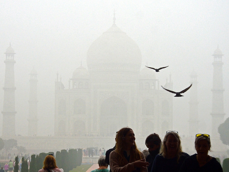 Tourists visit the Taj Mahal on a cold, smoggy morning in Agra on November 18, 2024. On Monday, northern India witnessed AQI at "hazardous" levels in several cities, with that of New Delhi crossing 900 at one point.