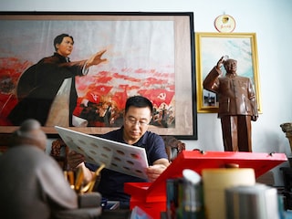 Former soldier and Mao memorabilia collector Feng Gang looks at his displays of pins featuring the image of late Chinese communist leader Mao Zedong. Photography Greg Baker / AFP©