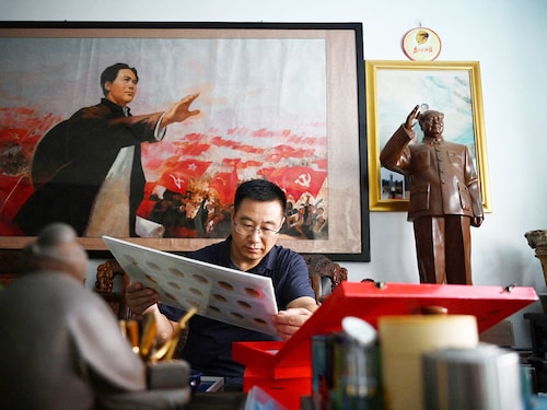 Former soldier and Mao memorabilia collector Feng Gang looks at his displays of pins featuring the image of late Chinese communist leader Mao Zedong. Photography Greg Baker / AFP© Former soldier and Mao memorabilia collector Feng Gang looks at his displays of pins featuring the image of late Chinese communist leader Mao Zedong. Photography Greg Baker / AFP©