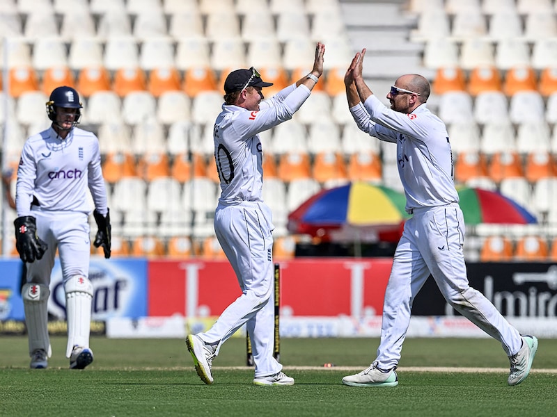 England"s captain Ollie Pope (C) celebrates with teammate Jack Leach (R) after winning the first Test cricket match between Pakistan and England at the Multan Cricket Stadium in Pakistan"s Multan on October 11, 2024. Spinner Leach grabbed four wickets to help England beat Pakistan taking a 1-0 lead in the three-match series.