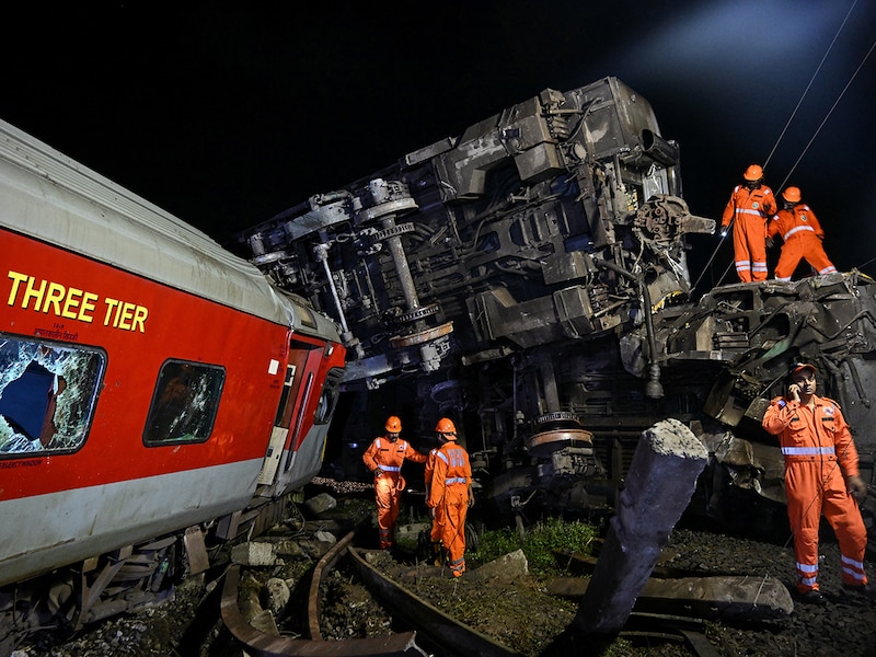 Members of the National Disaster Response Force (NDRF) inspect the site after several coaches of the Mysuru-Darbhanga Bagmati Express (12578) train derailed after ramming into the rear of a goods train at the Kavaraipettai Railway Station, located near Gummidipoondi, some 40km north of Chennai, in the early hours of October 12, 2024.
