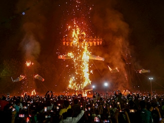 People watch the effigies of Hindu demon Ravana (C), his son Meghnath (R) and brother Kumbhkaran (L) burn on the occasion of the festival Dussehra (Vijaydashmi) in Varanasi on October 12, 2024.