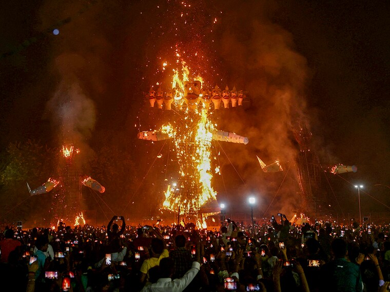 People watch the effigies of Hindu demon Ravana (C), his son Meghnath (R) and brother Kumbhkaran (L) burn on the occasion of the festival Dussehra (Vijaydashmi) in Varanasi on October 12, 2024.