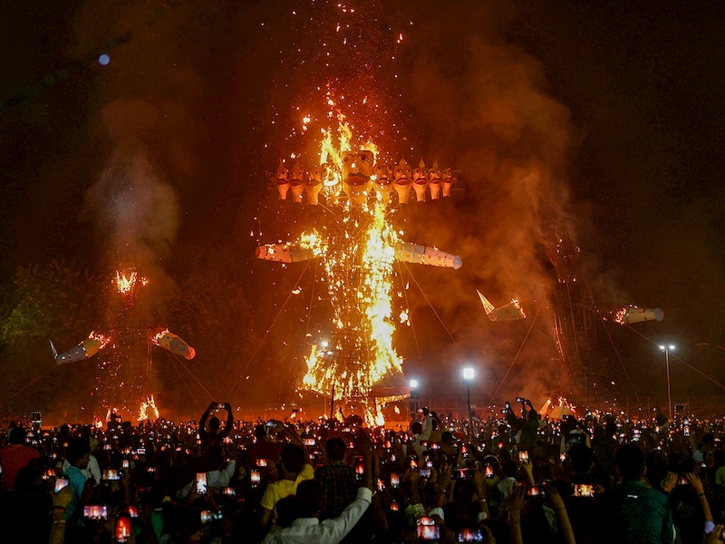 People watch the effigies of Hindu demon Ravana (C), his son Meghnath (R) and brother Kumbhkaran (L) burn on the occasion of the festival Dussehra (Vijaydashmi) in Varanasi on October 12, 2024.