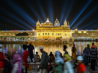 Sikh devotees pay their respects on the eve of the birth anniversary of the fourth Sikh Guru Ramdas at the illuminated Golden Temple in Amritsar on October 18, 2024.