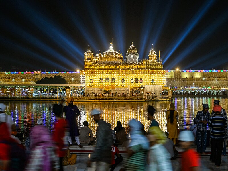 Sikh devotees pay their respects on the eve of the birth anniversary of the fourth Sikh Guru Ramdas at the illuminated Golden Temple in Amritsar on October 18, 2024.