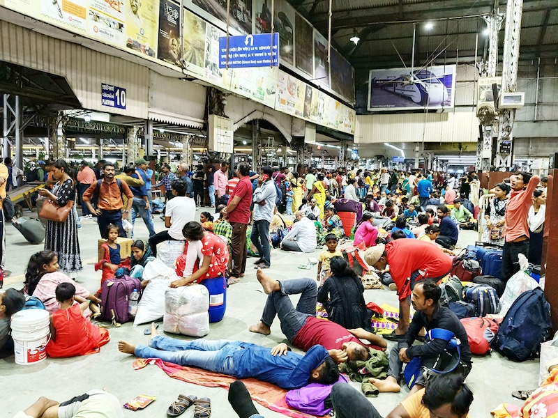 Passengers rest and wait at Howrah train station in Howrah, West Bengal, India, on October 23, 2024. East Coast Railways cancels as many as 198 trains passing through and originating from Odisha. As Odisha and West Bengal brace for cyclonic storm Dana, likely to intensify into a severe storm on Thursday, Indian Railways cancels more than 300 trains.