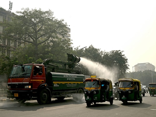 A vehicle (L) of the Public Works Department (PWD) sprays water using an anti-smog gun to curb air pollution amid smoggy conditions in New Delhi on October 22, 2024.
Image: Money Sharma/ AFP A vehicle (L) of the Public Works Department (PWD) sprays water using an anti-smog gun to curb air pollution amid smoggy conditions in New Delhi on October 22, 2024.
Image: Money Sharma/ AFP