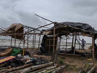 A villager stands near a damaged temporary house following the landfall of cyclone Dana in East Midnapore district around 180km southwest of Kolkata, on October 25, 2024. Cyclone Dana uprooted trees and power lines after making landfall on India"s east coast, with officials warning of more fierce weather on October 25.