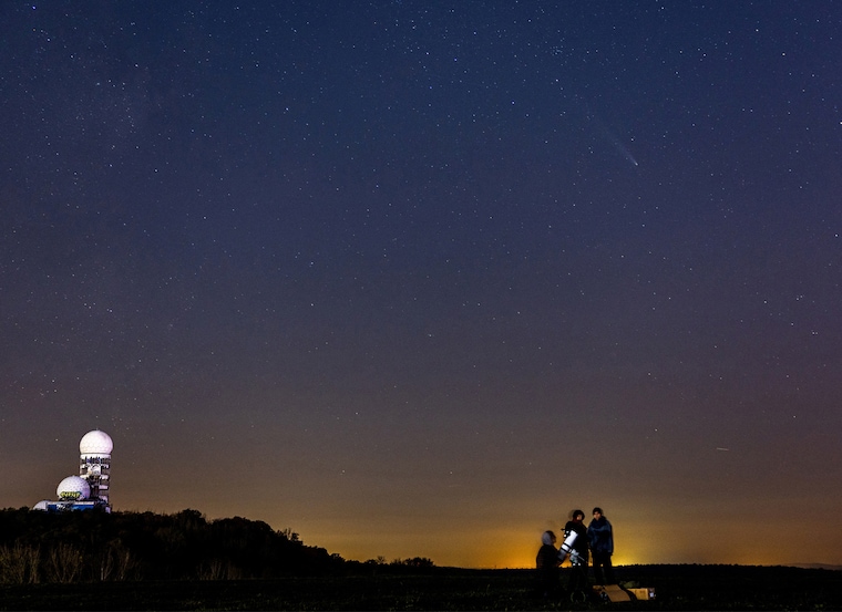 People stand next to a telescope as comet C/2023 A3 (Tsuchinshan-ATLAS), known as the comet of the century, is visible in the night sky over the former Cold War radar station Teufelsberg in Berlin, Germany, on October 25, 2024