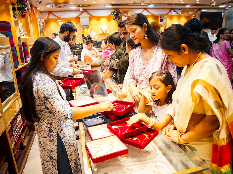 People buy gold ornaments at a jewelry showroom during Dhanteras in Guwahati, India, on October 29, 2024. On Dhanteras, people traditionally buy precious metals like gold, silver, or even new utensils, as it is believed this brings wealth and good luck into the household.