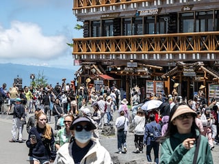 Tourists are seen in front of the restaurant and shopping area of the Fuji Subaru Line 5th station, which leads to the popular Yoshida trail for hikers climbing Mount Fuji. Image: Photography Philip FONG / AFP