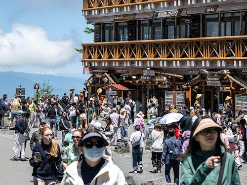 Tourists are seen in front of the restaurant and shopping area of the Fuji Subaru Line 5th station, which leads to the popular Yoshida trail for hikers climbing Mount Fuji. Image: Photography Philip FONG / AFP Tourists are seen in front of the restaurant and shopping area of the Fuji Subaru Line 5th station, which leads to the popular Yoshida trail for hikers climbing Mount Fuji. Image: Photography Philip FONG / AFP