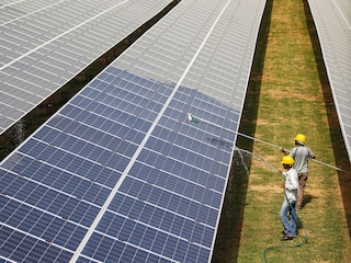 Workers clean photovoltaic panels inside a solar power plant in Gujarat, India.
Image: Reuters/Amit Dave