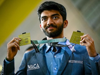 Gold medallist grandmaster Dommaraju Gukesh, shows his medals upon his arrival at the Chennai International Airport in Chennai on September 24, 2024, after his win at the 45th FIDE Chess Olympiad Budapest 2024.