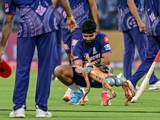 Rajasthan Royals" Kumar Kartikeya plays with the robot dog before the start of the Indian Premier League (IPL) Twenty20 cricket match between Delhi Capitals and Rajasthan Royals at the Arun Jaitley Stadium in New Delhi on April 16, 2025. IPL 2025 now features a robot dog that not only films the players" behind-the-scenes moments from the camera mounted on it but also plays around with the cricketers.
