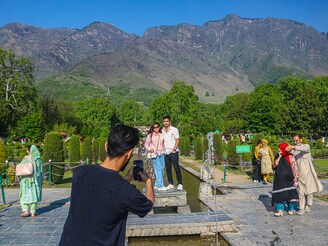 Indian tourists take pictures inside the Nishat Mughal Garden in Srinagar, Jammu and Kashmir, on April 27, 2025. The Pahalgam attack leads to the cancellation of nearly 80 percent of tourist bookings in the valley, delivering a severe blow to the tourism sector, which contributes significantly to the region"s GDP. This setback comes at a time when the region witnesses back-to-back tourism booms and hopes for a bumper tourist season this year as well.