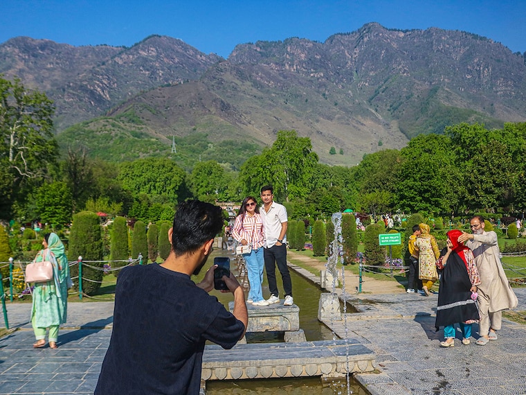 Indian tourists take pictures inside the Nishat Mughal Garden in Srinagar, Jammu and Kashmir, on April 27, 2025. The Pahalgam attack leads to the cancellation of nearly 80 percent of tourist bookings in the valley, delivering a severe blow to the tourism sector, which contributes significantly to the region"s GDP. This setback comes at a time when the region witnesses back-to-back tourism booms and hopes for a bumper tourist season this year as well.