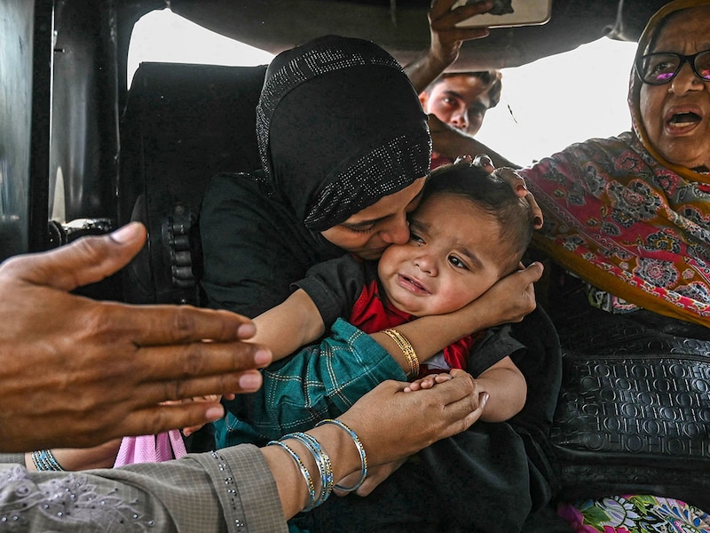 A Pakistani citizen (L) kisses goodbye to her son, an Indian citizen, as she prepares to return to her country through the India-Pakistan Wagah border post, about 35kms from Amritsar on April 29, 2025.