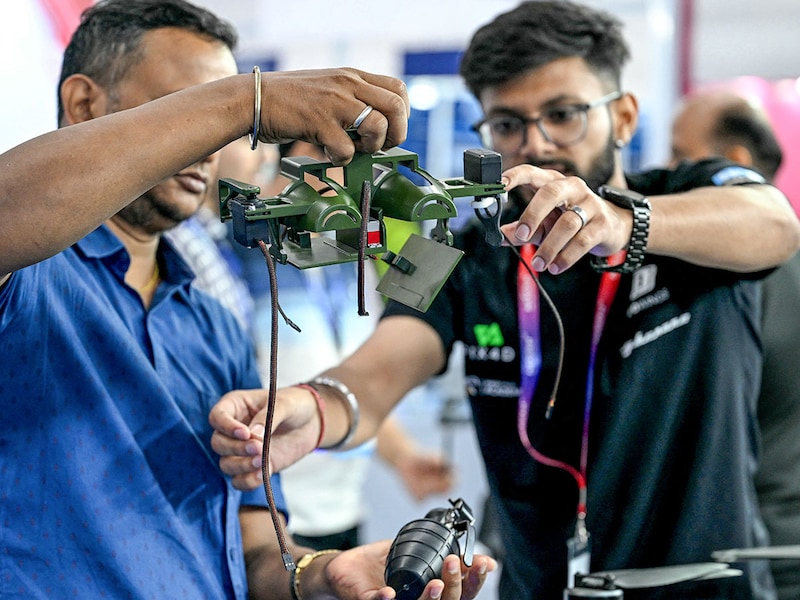 An exhibitor explains the working of a grenade-carrying drone at the International Police and Drone Expo 2025 in New Delhi on July 31, 2025. Drones, AI-powered defence systems, anti-drone guns, armoured ambulances, and mobile forensic tools were showcased at the event, which drew over 4,000 police and defence personnel on its opening day.