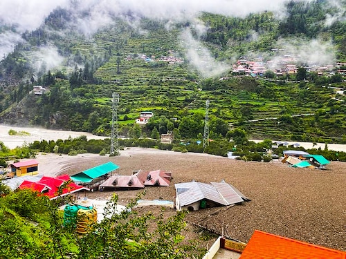 This handout photograph taken on August 5, 2025 and released by the Indian Army shows residential buildings partially submerged in sludge after a cloudburst caused a massive mudslide in India"s Uttarakhand state. A flash flood driving a torrent of mud smashed into a town in India"s Himalayan region on August 5, tearing down a mountain valley before demolishing buildings and killing at least four people.