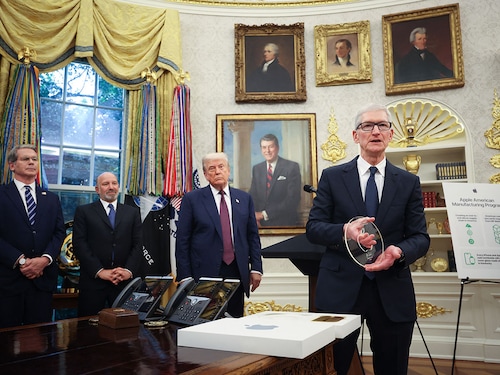 Apple CEO Tim Cook (R) displays an engraved glass disc presented to U.S. President Donald Trump during an event in the Oval Office of the White House on August 6, 2025 in Washington, DC. Apple Inc. announced a $100 billion investment in manufacturing facilities in the U.S., on top of an announcement in February committing over the next four years to a $500 billion investment in the U.S. economy and the addition of 20,000 new jobs.   
Image: Win McNamee/Getty Images/AFP