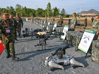 (File) Deputy Commander-in-Chief of the Royal Cambodian Armed Forces and commander of the Royal Cambodian Army, General Mao Sophan (L), inspects drones and a machine gun equipped robot battle "dog" (R) displayed in front of Chinese soldiers during the Cambodian-Chinese Dragon Gold-2024 drill at a military police base in Kampong Chhnang province on May 16, 2024. 
Image: Tang Chhin Sothy/ AFP