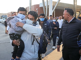 Indian immigrants deported from the US walk out of the airport in Ahmedabad, India on February 6, 2025.