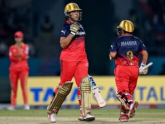 Royal Challengers Bengaluru"s Richa Ghosh (C) celebrates after scoring a match winning half-century during the Women"s Premier League T20 inaugural cricket match between Gujarat Giants and Royal Challengers Bengaluru at the Kotambi Stadium in Vadodara on February 14, 2025.