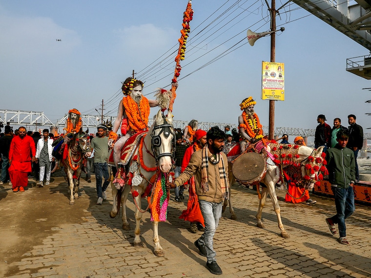Hindu holy men or Sadhus ride horses during a religious procession of Atal Akhara, ahead of the Maha Kumbh Mela festival in Prayagraj on January 1, 2025.