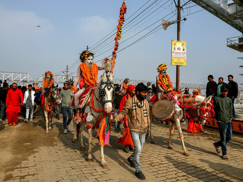 Hindu holy men or Sadhus ride horses during a religious procession of Atal Akhara, ahead of the Maha Kumbh Mela festival in Prayagraj on January 1, 2025.